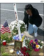 A woman grieves at the site of a shooting