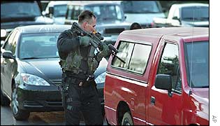 An armed officer checks a vehicle near Washington