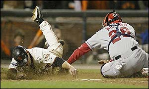 J.T Snow touches home plate ahead of the tag from Angels catcher Bengie Molina