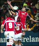 Llanelli's Chris Wyatt just beats Ulster Gary Longwell to the ball