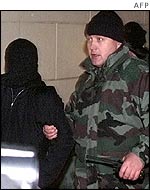 Unidentified Chechen rebel (left) being led away by Russian special forces agent