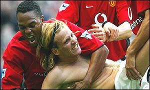 Manchester striker Diego Forlan is mobbed by his team-mates after equalising