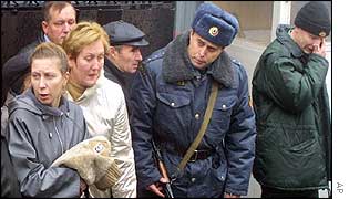 Distraught relatives outside Hospital 13 with an armed policeman wait for news of relatives