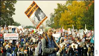 Girl with a placard stands by Constitution Gardens in Washington DC as the rally begins behind her 