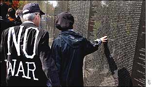 Two anti-war protesters pause to read the names on the Vietnam War Memorial in Washington DC
