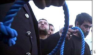Officials with a noose for convicted killer Hashem Anwarniah (r)