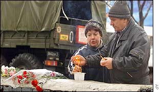 A couple lights a candle outside the theatre
