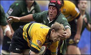 Matt Dawson of Northampton ducks under the challenge of Kevin Burke