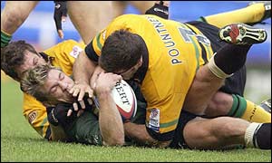 Exiles' Justin Bishop is held by Northampton's Budge Poutney