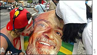 Two Lula supporters kiss a poster depicting him