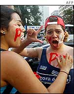 Two Lula supporters in Sao Paolo paint 