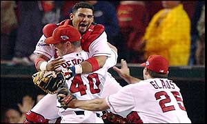 Anaheim Angels catcher Bengie Molina (L) jumps into the arms of closing pitcher Troy Perceval (centre) as Troy Glaus rushes to celebrate 