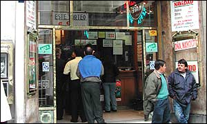 Lottery players loiter outside a shop