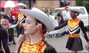 Cheerleaders, one white and one black, march in a Texas parade