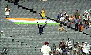 An Indian fan cheers on his side from an almost empty stand
