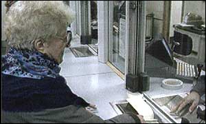 An elderly woman collecting her pension at a post office