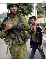 Israeli troops detain a Palestinian