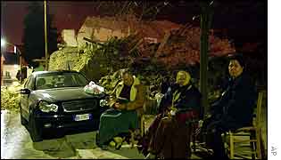 Villagers try to sleep in chairs by their car