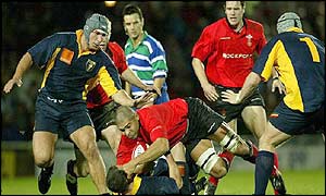 Welsh captain Colin Charvis is blocked by Romania scrum-half Petre Mitu