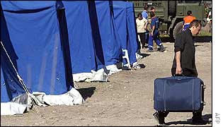 Earthquake victim carries his belongings by a row of tents near San Giuliano Di Puglia 