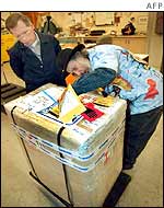Officials examine the ossuary in its packing case