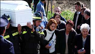 Families walk alongside the coffins as they carried by Italian rescuers and firefighters