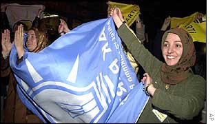 Female supporters of the AK wave a party flag outside its headquarters in Ankara 