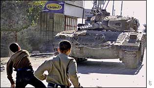 Stone throwing Palestinian boys face Israeli tank