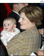 Laura Bush holds a young baby during a campaign rally in South Dakota