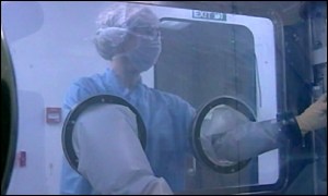 Laboratory worker in hazardous materials suit