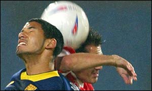 Wimbledon midfielder Joel McAnuff contests a high ball with Rotherham's Darren Garner 