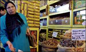 Egyptian woman buys dates in a Cairo market marked Saddam Hussein Mass Destruction