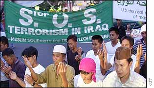 A group of Filipino Muslims pray outside the US embassy in Manila during an anti-US rally