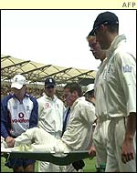 Simon Jones is led off on a stretcher