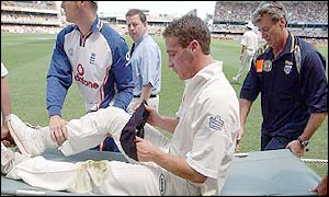 Simon Jones is led off on a stretcher