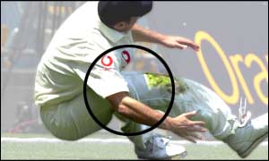 Simon Jones appears to get his spikes stuck in the sandy grass on the Gabba outfield