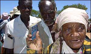 People queuing for food aid with their identity cards