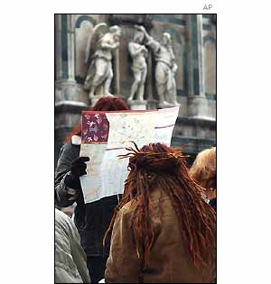 Protesters read a street map