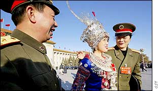 Military delegates pose for a photo with an ethnic Miao minority delegate from south-west China