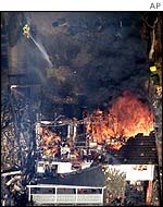 Firefighter hosing burning house in Sydney suburbs