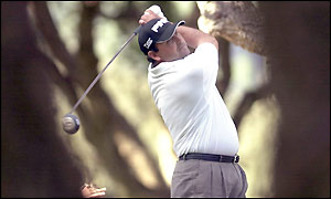 Angel Cabrera plays a shot from between the trees as he finishes the day four shots up