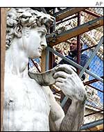 A man boards up a replica of Michelangelo's David
