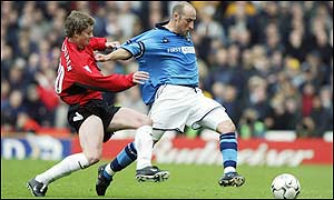 Manchester City's Danny Tiatto holds off Ole Gunnar Solskjaer of Manchester United