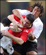 Wales fly-half Stephen Jones is tackled by opposite number Nicky Little
