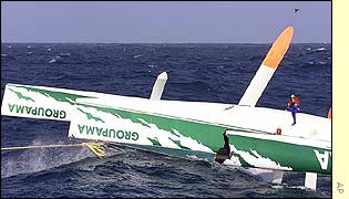 French yachtsman Franck Cammas sits on his overturned yacht Groupama 
