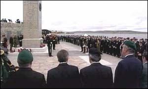Veterans stand to attention at the war memorial