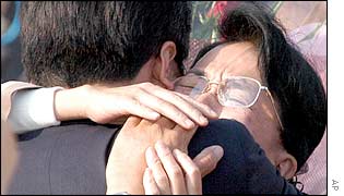 Kidnap survivor Fukie Hamamoto (right) cries as she is hugged by a family member