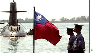Two Taiwanese sailors stand guard, as submarine is seen in the background, Tsoying Naval Base