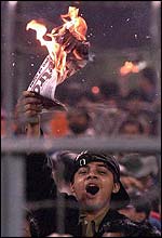 An Indian fan sets fire to newspaper