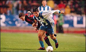 Turu Flores of Deportivo La Coruna holds off AC Milan's Thomas Helveg 